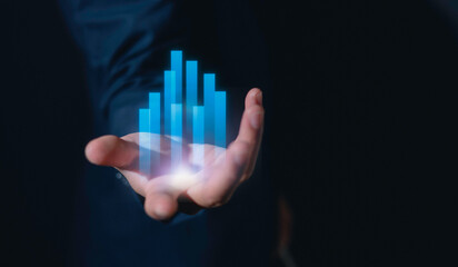 investment and finance concept, businessman holding virtual trading graph and blurred light on...