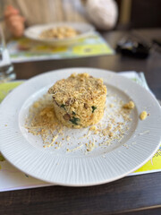 Plate of gourmet risotto served with grated cheese and a crispy topping, presented elegantly on a white dish. Culinary sophistication and restaurant concept