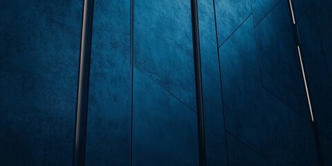 Slender black frames leaning against a textured dark blue wall with diagonal patterns creating a modern, artistic composition.