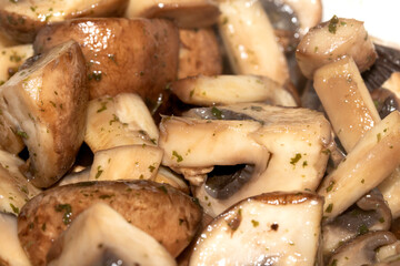 Close Up of a Chopped and Fried Cooked Chestnut Mushroom with Parsley Herb on White Background
