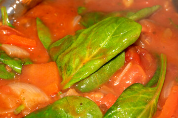 Close Up of a Tomato Basil Leaf Ragu Soup Cooking With Herbs and Vegetables