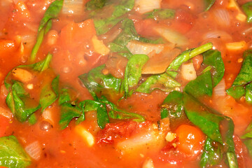 Close Up of a Tomato Basil Leaf Ragu Soup Cooking With Herbs and Vegetables