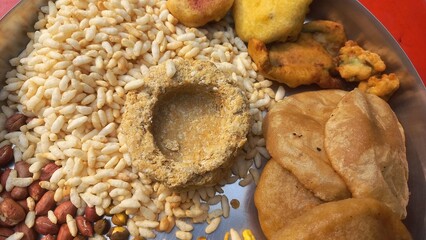 Food items consumed by Bengalis during Makar Sankranti festival are Narkel Naru (coconut sweet made with jaggery) Moa (round puffed jaggery rice) and Tilkut sweets and puffed rice rotis with peanut an