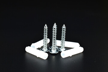 Wall screws with dowels lie on a black background.