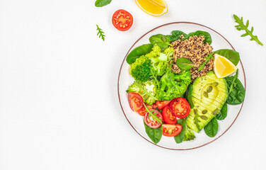 healthy vegan lunch bowl with avocado, broccoli, quinoa, tomatoes and fresh herbs on a white background top view. copy space