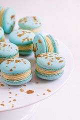French blue macarons with blue vein cheese and pear sprinkled with crumbs isolated on white plate