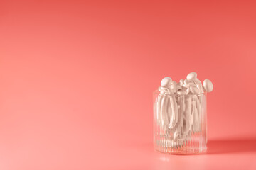shimeji mushrooms in glass, on peach fuzz background