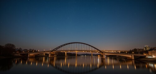 Naklejka premium Stone bridge over calm river under a starry night sky
