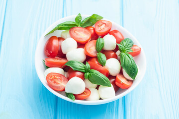 Basil leaves , cherry tomatoes and mozzarella cheese . In bowl food photography