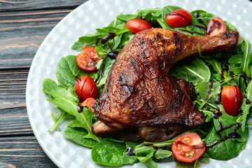 Grilled chicken legs with tomatoes and salad . Top view