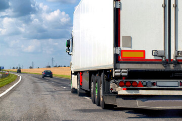 A beautiful truck transports cargo along the highway in the summer. Concept of a cargo transport company. Work and vacancies as a freight forwarder driver. Copy space for text