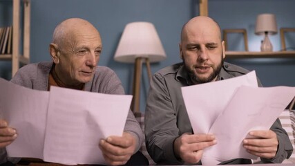 father and son discussing household bills and budget