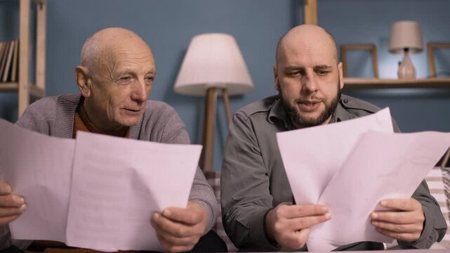 father and son discussing household bills and budget