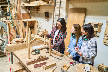 Young apprentices receiving woodworking training in a lumberyard workshop