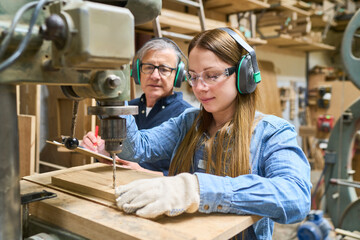 Young apprentice and mentor working together in a lumberyard
