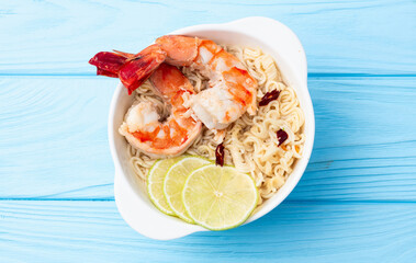 Tom yum soup with shrimps instant noodles and lime photography . Asian food . Top view