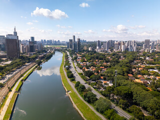 aerial view of Sao Paulo city in Brazil with a park, buildings, and Pinheiros river crossing the...