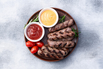 Grilled beef sausages with rosemary sauce and tomatoes photography . Top view