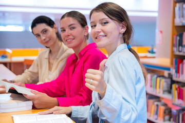 Smiling women studying together at a library table