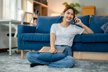 A woman is sitting on the floor in front of a blue couch