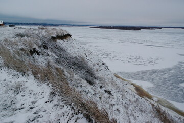 frozen river and high bank in winter