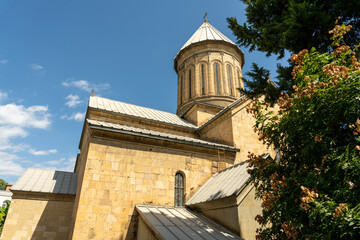 A large building with a steeple and a window. The building is brown and has a lot of detail