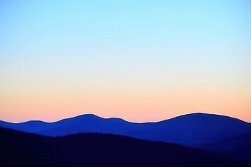 Obraz premium Mountain Range Gradient: Mountains in silhouette with a gradient sky from dark blue at the peak to a light blue at the base