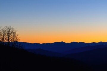 Mountain Range Gradient: Mountains in silhouette with a gradient sky from dark blue at the peak to a light blue at the base