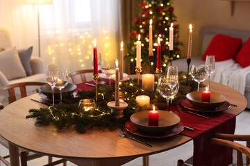Festive table setting in room decorated for Christmas. Bokeh effect
