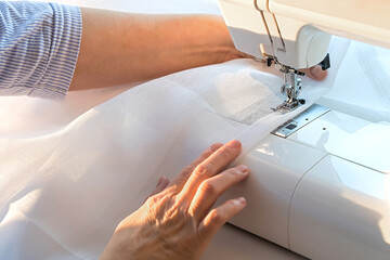 A person is sewing a piece of fabric with a sewing machine