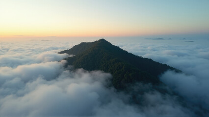 Mountain peak rises above the clouds at sunrise showcasing breathtaking natural beauty and tranquility