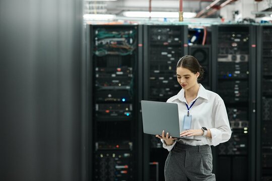 Woman in a white shirt collaborates with network systems in a contemporary data center.