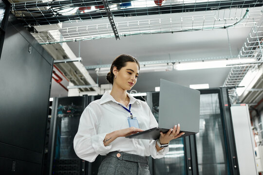 IT specialist in a white shirt manages systems in a high-tech data center with confidence.