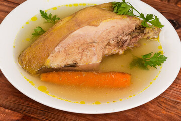 Boiled domestic chicken breast on bone in bouillon close-up