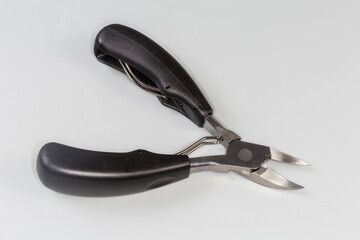 Professional pedicure nail clipper with curved blades on gray background