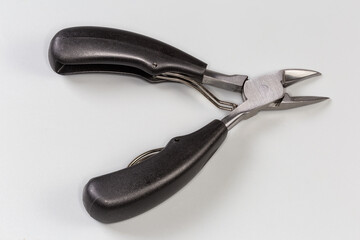 Obraz premium Professional pedicure nail clipper with curved blades on gray background