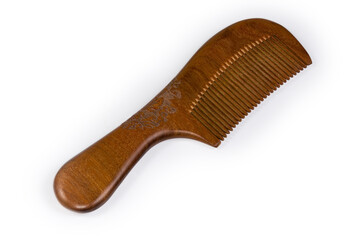 Wooden hair comb with engraved plant design on white background