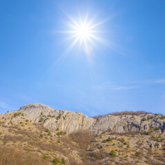 mountain ridge under a sparkle sun on blue sky