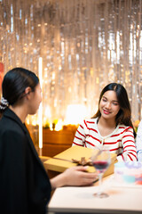 Young asian woman receiving gifts in her birthday party celebration with friends.