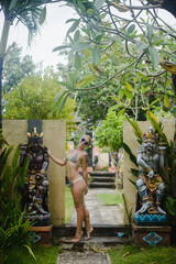 Blonde woman on the territory of a tropical hotel by the pool