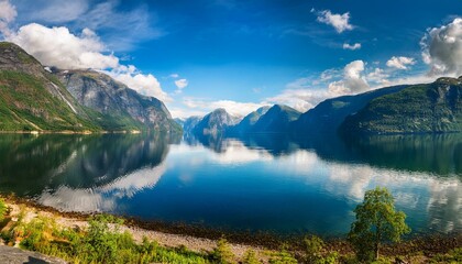 a serene view of the sognefjord in western norway captured near vindedalen the tranquil blue water reflects dramatic clouds and majestic mountains on both sides