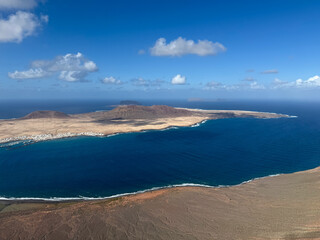 Breathtaking view from above from Mirador del Rio view point of Atlantic ocean, volcanic landscape and La Graciosa island on sunny day