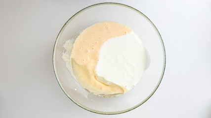 A glass bowl of cake batter being mixed, representing baking preparations for a holiday celebration, like Christmas