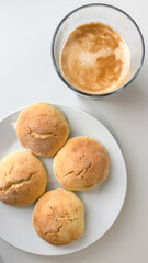 A warm cup of coffee paired with freshly baked scones on a plate, evoking a cozy breakfast concept