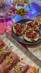 A festive Italian antipasto spread featuring prosciutto-wrapped appetizers and bruschetta, perfect for a vibrant holiday celebration
