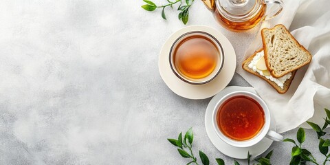 Elegant breakfast set featuring two cups of tea and ricotta cheese sandwiches with pear jam on a light background with greenery accents.