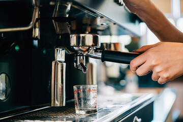Espresso machine in cafe brewing coffee. Fresh espresso pouring into glasses demonstrating modern coffee making technology. Flowing liquid steam smooth service in coffee shop.
