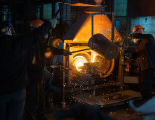 Pouring molten metal into a centrifugal machine in the foundry shop of metallurgical plant