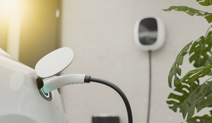 Electric car charging with EV charger at home, modern ev charger handle pluged on electric verhicle...
