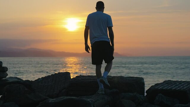 Persona sentado frente al mar mientras atardecer